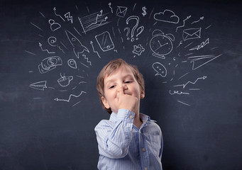 Smart little kid in front of a drawn up blackboard ruminate