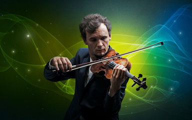 Fototapeta premium Serious classical violinist with fabled sparkling wallpaper