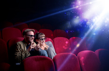 Obraz premium Romantic couple cuddling and watching the miraculous part of the film