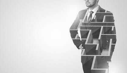 Young businessman in suit standing with maze graphic 