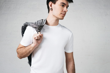Studio portrait of young pensive guy in white blank t shirt and jacket, horizontal