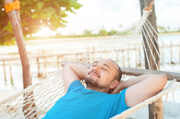 Time for laziness. The man lies in a hammock and enjoys the rest