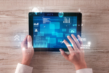 Caucasian business hands holding tablet with blue business-statistics screen