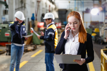Obraz premium Young female engineer using clipboard.Female quality inspector at factory