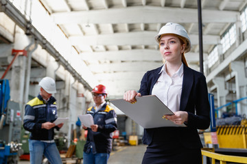 Young female engineer using clipboard.Female quality inspector at factory