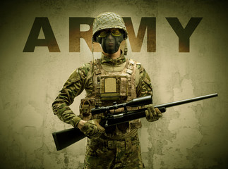 Uniformed armed soldier with damaged wall background
