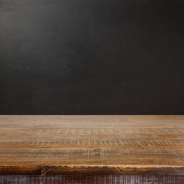 Empty wooden table over chalkboard background