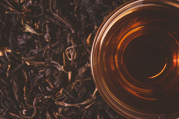 close-up of a cup of chinese tea on dry tea leaves background, vintage tone