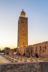 Fototapeta premium Minaret of Koutoubia Mosque with Ruins of Old Mosque at sunrise in Marrakech, Morocco.