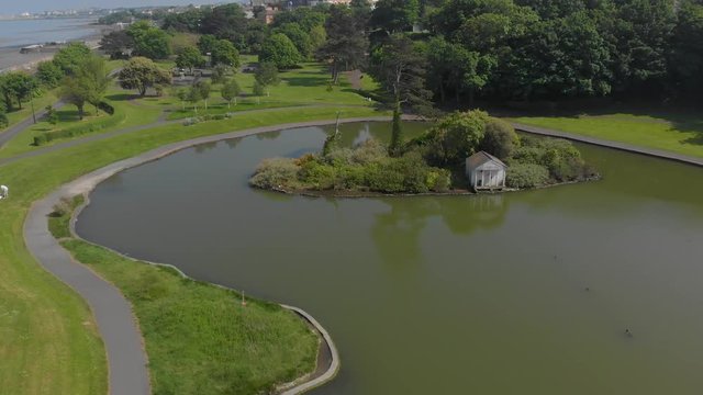 Drone flying and top view of little artificial lake in the park, blackrock park, dublin, ireland