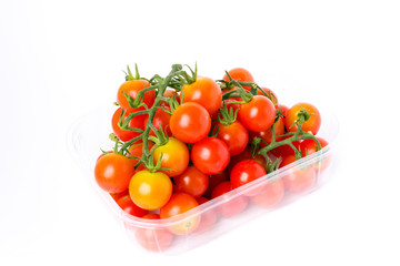 Cherry tomatoes on a branch in transparent retail plastic box