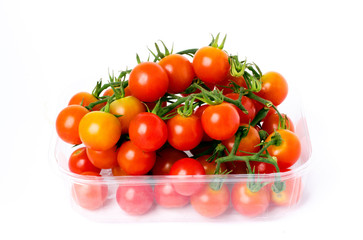 Cherry tomatoes on a branch in transparent retail plastic box