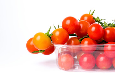 Cherry tomatoes on a branch in transparent retail plastic box