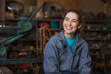 young woman mechanic in a workshop - obrazy, fototapety, plakaty