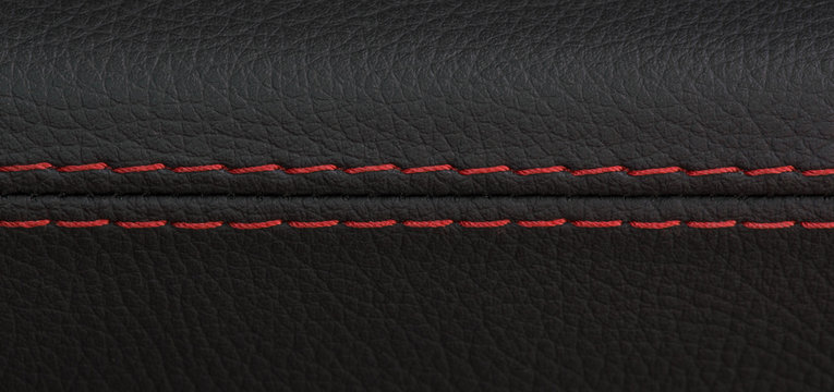 closeup shot of black leather car seat with red stitch,sports luxury car