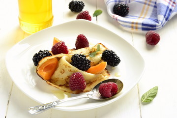 Pancakes, fresh berries sprinkled with powdered sugar - delicious breakfast
