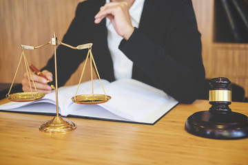 Judge gavel with Justice lawyers having team meeting at law firm in background. Concepts of law.