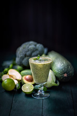 vegetarianism and a healthy lifestyle. green vegetables on a dark background.  breakfast.Green vegetable drink-smoothie