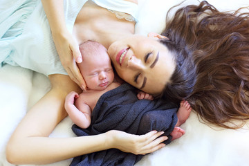 Obraz na płótnie Canvas Portrait of a sleeping newborn baby with a mother