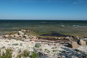 rocky sea beach with waves and sunny day