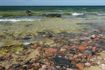 rocky sea beach with waves and sunny day