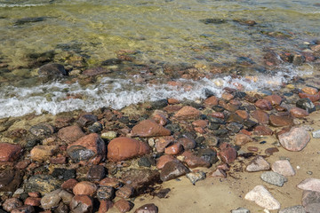 rocky sea beach with waves and sunny day
