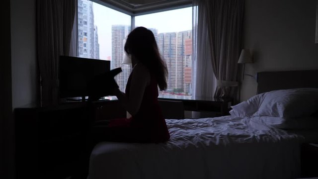 Woman undress sitting on bed, remove sweater