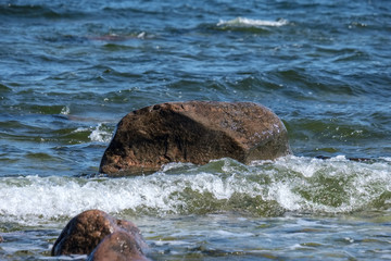 rocky sea beach with waves and sunny day