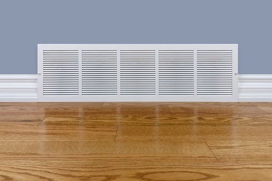 Wall Cold Air Return Grille Sitting On Hardwood Floor