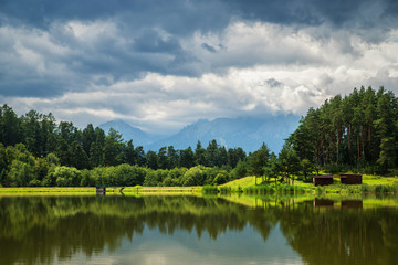 Fototapeta na wymiar Lake and forest with mountains and clouds in background, Slovakia
