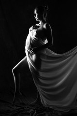 Pregnant girl on black background with big belly