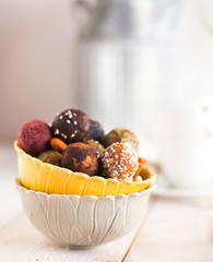 Assorted raw vegan sweet candy gluten-free balls with carob,  coconut and poppy seeds almonds nuts