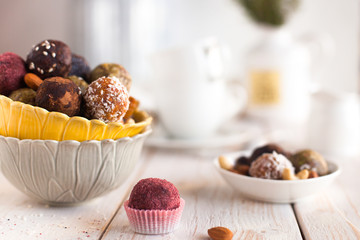 Assorted raw vegan sweet candy gluten-free balls with carob,  coconut and poppy seeds almonds nuts
