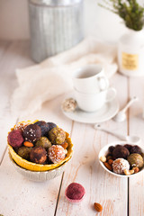 Assorted raw vegan sweet candy gluten-free balls with carob,  coconut and poppy seeds almonds nuts