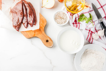 Sliced raw beef liver with spices, herbs, milk and flour, white marble table copy space top view