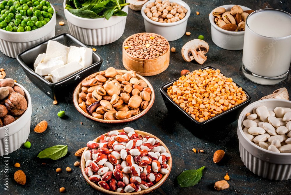 Wall mural Healthy diet vegan food, veggie protein sources: Tofu, vegan milk, beans, lentils, nuts, soy milk, spinach and seeds. Top view on white table. - Wall murals