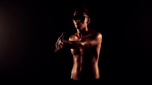 Sexy man dancing on black background