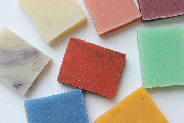 Many small multi-colored pieces of handmade soap on white background