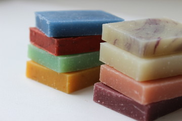 Many small multi-colored pieces of handmade soap on white background