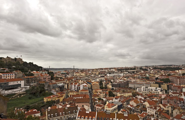 Fototapeta na wymiar Aussicht vom Miradouro da Graca auf die Burg Castelo de Sao Jorge und die Stadt bei bewölktem HImmel, hinten die Brücke Ponte 25 de Abril, Lissabon; Lisboa; Portugal