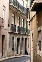 Fototapeta na wymiar Alter Mann sitzt allein auf einem Fenstersims im Stadtteil Mouraria, Lissabon; Lisboa; Portugal