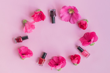 Flat lay pattern with pink flowers and female cosmetics