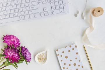 Blogger or freelancer workspace with notebook and pink flowers