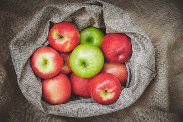 Organic apples in basket cover with sackcloth on background texture, Fresh apples with copy space