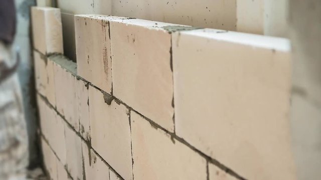 4K Time lapse of a construction worker or a mason or a bricklayer installing brick with trowel  for a wall