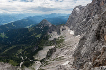 Bergwand mit Schotterriese und grüner Landschaft