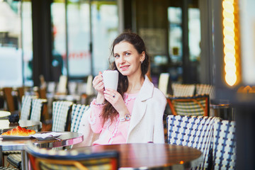 Woman drinking coffee in outdoor cafe or restaurant, Paris, France