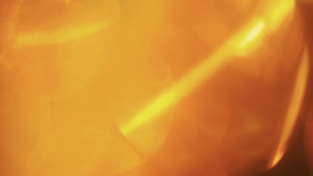 Orange warm light pulses and glows on dark background.