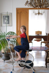 A boy of school age sits on an old exercise bike