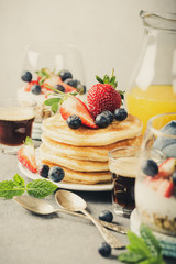 Breakfast composition with fresh pancakes and berries on light gray concrete background. Healthy food concept with copy space. Retro style toned.